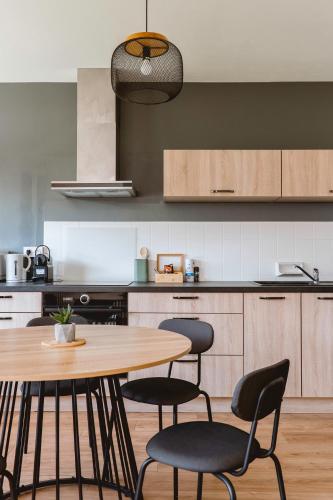 a kitchen with a wooden table and chairs at Chamalières Appartement moderne pour 5 personnes in Chamalières