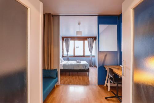 a room with a bedroom with a bed and a desk at Chamalières Appartement moderne pour 5 personnes in Chamalières