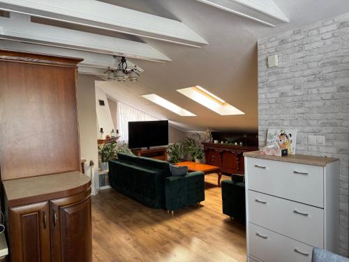 a living room with a couch and a tv at 2 pokojowy apartament in Dąbki