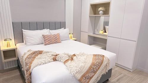 a bedroom with a white bed and a chair at Belmoral Corporate Suites in Townsville
