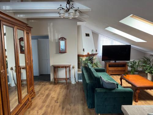a living room with a green couch and a flat screen tv at 2 pokojowy apartament in Dąbki
