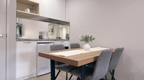 a kitchen with a wooden table and chairs at Belmoral Corporate Suites in Townsville