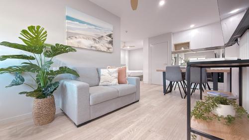 a living room with a couch and a dining room at Belmoral Corporate Suites in Townsville