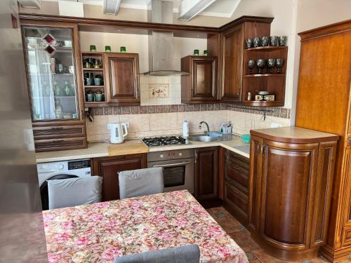 a kitchen with wooden cabinets and a table in it at 2 pokojowy apartament in Dąbki