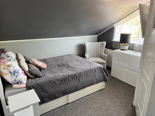 a bedroom with a bed and a chair at 2 pokojowy apartament in Dąbki
