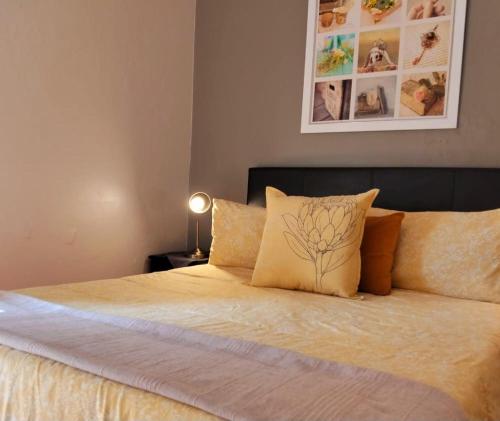 a bed with yellow sheets and pillows in a bedroom at Glen Lilly Self Catering in Parow
