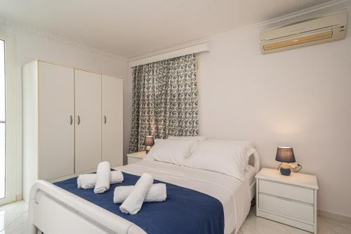 a bedroom with a bed with towels on it at Irene Luxury Apartments in Metaxáta
