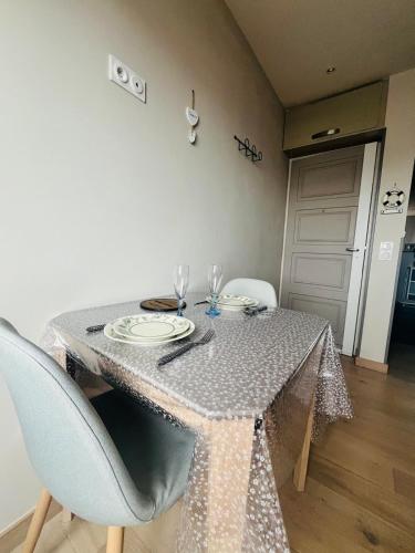 a table with chairs and a table cloth on it at Le Nid Marin, Cayeux-sur-Mer, Baie de Somme in Cayeux-sur-Mer