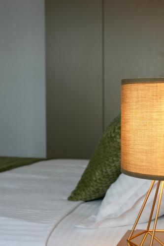 a close up of a bed with a lamp at Flat in Otopeni in Otopeni
