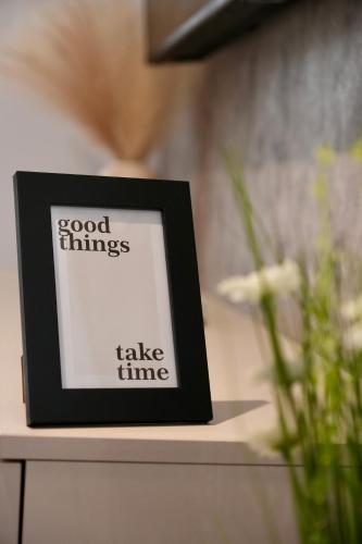 a picture frame sitting on a table next to a plant at Flat in Otopeni in Otopeni