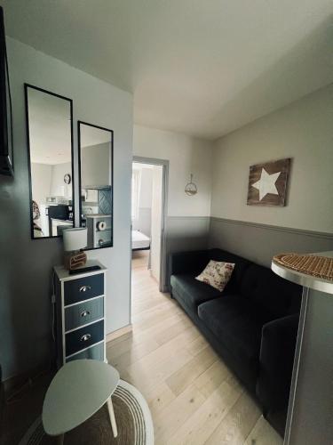 a living room with a couch and a mirror at Le Nid Marin, Cayeux-sur-Mer, Baie de Somme in Cayeux-sur-Mer