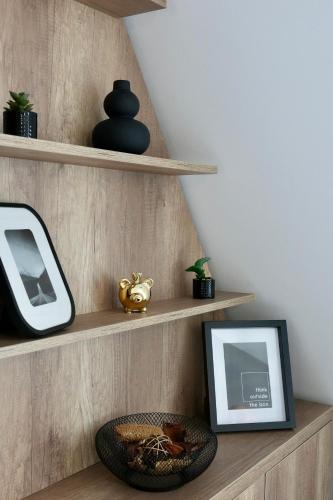 a room with wooden shelves with a picture and a frame at Flat in Otopeni in Otopeni