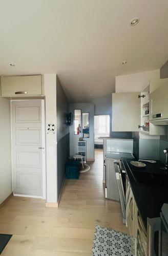 a kitchen with white cabinets and a white door at Le Nid Marin, Cayeux-sur-Mer, Baie de Somme in Cayeux-sur-Mer