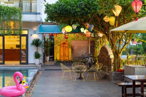 a patio with a pool and a pink flamingo at Blessing Villa Hoi An in Hoi An