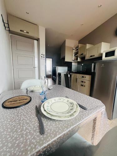 a kitchen with a table with plates on it at Le Nid Marin, Cayeux-sur-Mer, Baie de Somme in Cayeux-sur-Mer