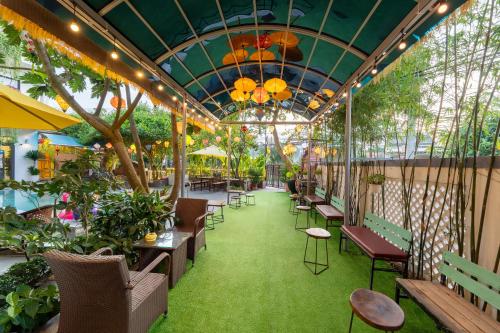 a patio with tables and chairs and plants at Blessing Villa Hoi An in Hoi An