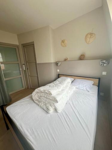 a bedroom with a bed with white sheets and pillows at Le Nid Marin, Cayeux-sur-Mer, Baie de Somme in Cayeux-sur-Mer