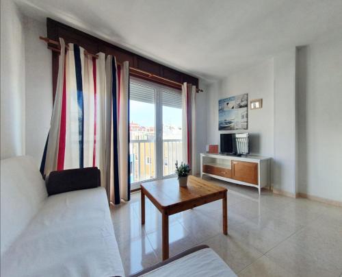 a living room with a couch and a table and a window at alquilaencanarias Tio Claudio Beach in El Médano