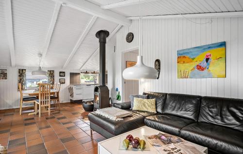 a living room with a leather couch and a table at Holiday Home Hedevej Xii Denmk in Ho