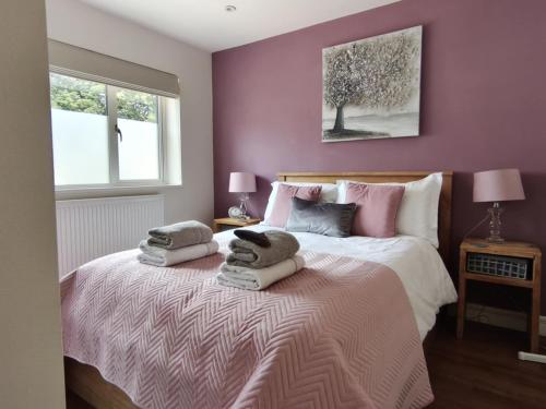 a bedroom with a bed with two pillows on it at Littleton Farm Barns in Saham Toney