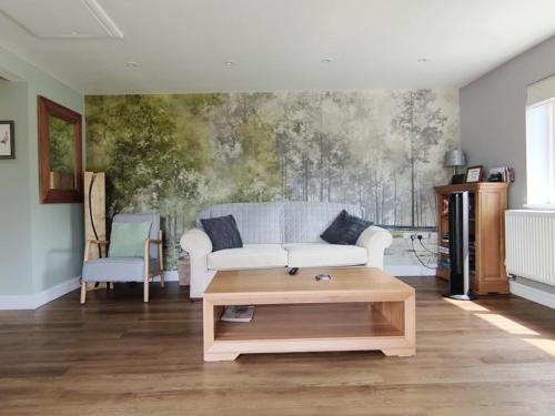 a living room with a white couch and a coffee table at Littleton Farm Barns in Saham Toney