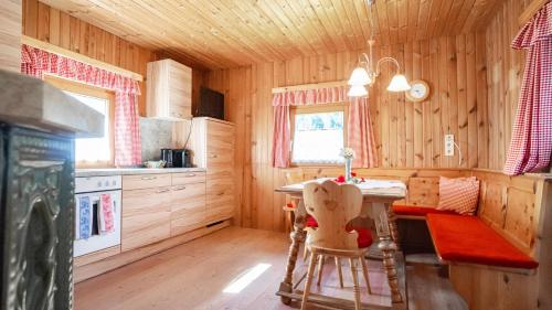 a kitchen with a table and chairs in a cabin at Huberbauer in Johnsbach