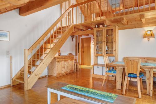 a large room with a wooden staircase and a table at Fewo Cheny mit Hochschwarzwaldcard in Titisee-Neustadt