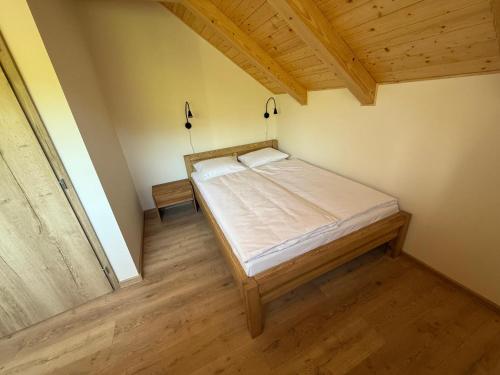 a bedroom with a bed in a room with wooden floors at Sklep Sklenka in Brod nad Dyjí
