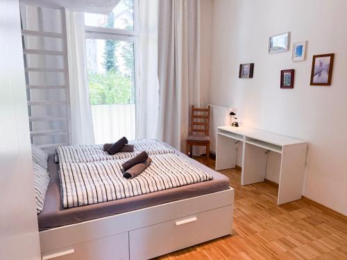 a bedroom with a bed with a desk and a window at NOVA Solis I Bright Escape near Cologne I 100 sqm and Large Terrace in Hürth