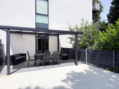 a patio with a table and chairs and a fence at NOVA Solis I Bright Escape near Cologne I 100 sqm and Large Terrace in Hürth