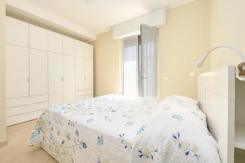 a white bedroom with a bed and a window at 320 - Casa Scorcio di Mare A due passi dal centro e dal mare di Riva Trigoso in Riva Trigoso