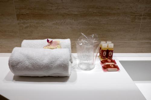 a bathroom counter with towels and bottles of honey at Chi in Barcelona