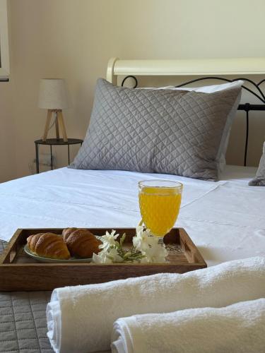 a tray of food and a glass of orange juice on a bed at Sunbeam house in Nea Makri