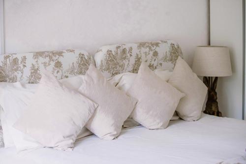 a pile of pillows on a bed in a bedroom at Leygreen Farmhouse B&B in Beaulieu