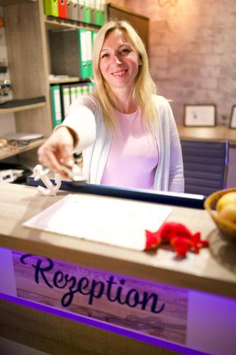 a woman sitting at a counter with a registration sign at BUDE16 Boardinghouse in Norden