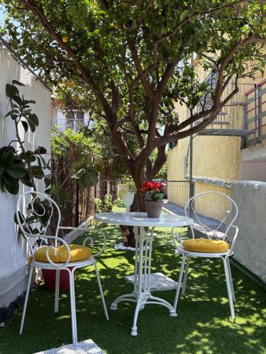 a table and chairs on the grass under a tree at Sunbeam house in Nea Makri