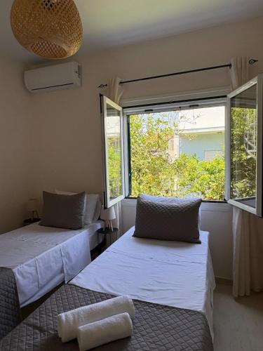 two beds in a room with a window at Sunbeam house in Nea Makri