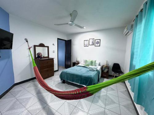 a hammock in a bedroom with a bed and a tv at Coronaditos 2-Bedroom Appartment in Colonos in Valladolid