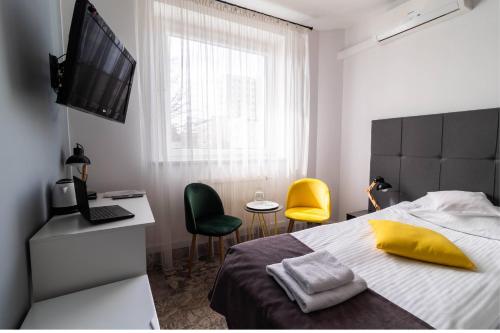 a bedroom with a bed and a desk and two chairs at Hotel Nafta Krosno in Krosno