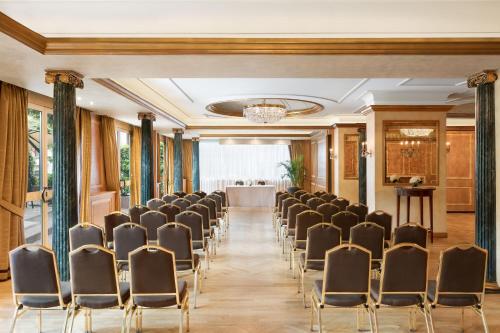 a room with a row of chairs and a table at The Westin Palace, Milan in Milan