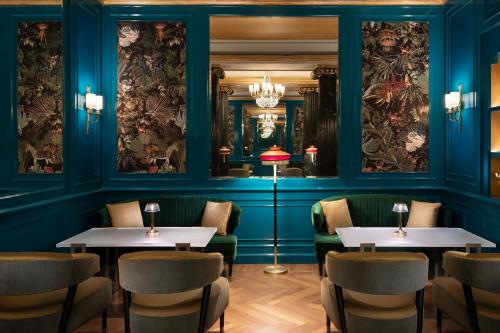 a restaurant with blue walls and tables and chairs at The Westin Palace, Milan in Milan