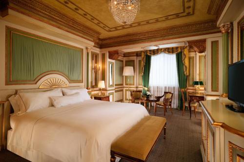 a bedroom with a large white bed and a desk at The Westin Palace, Milan in Milan