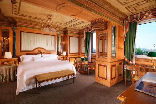 a bedroom with a large bed and a chandelier at The Westin Palace, Milan in Milan