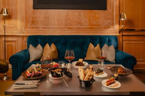 a table with food and wine glasses on a couch at The Westin Palace, Milan in Milan