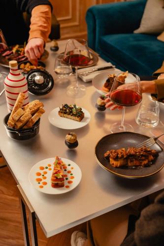 a table with plates of food and glasses of wine at The Westin Palace, Milan in Milan