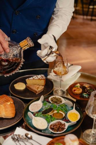 a chef preparing food on a table with plates of food at The Westin Palace, Milan in Milan