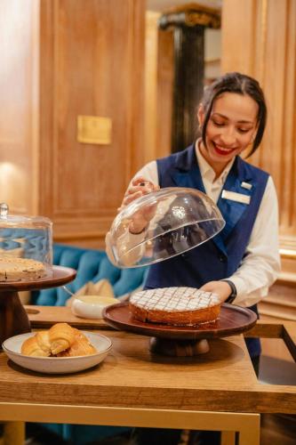 a woman is preparing food on a table at The Westin Palace, Milan in Milan