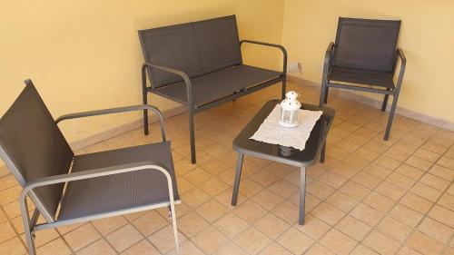 three chairs and a table with a candle on it at Casa Antonia in Vecchiano