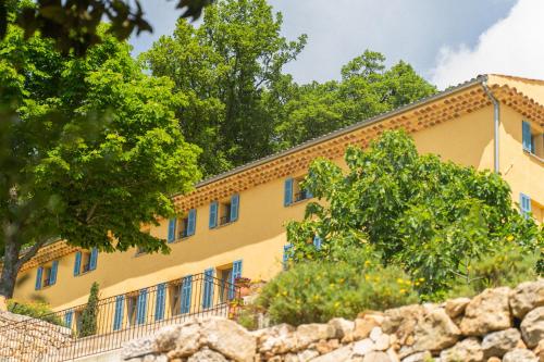 a yellow building with trees in front of it at Domaine de la Cascade Parfumée in Grasse