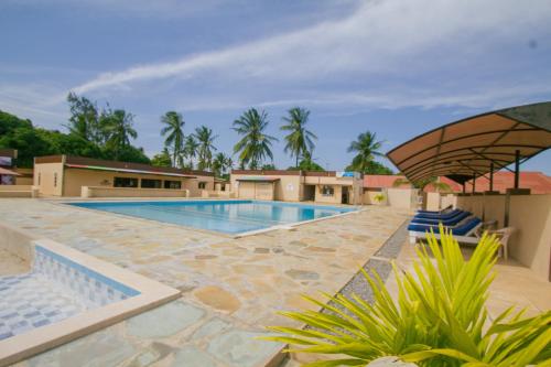 a swimming pool in a resort with palm trees at Havillah Gardens Watamu in Watamu